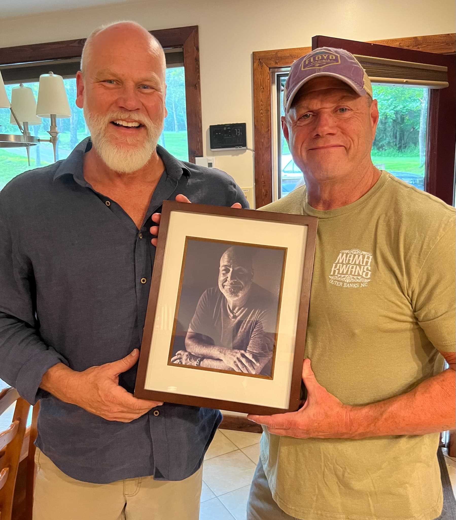 Two men holding framed portrait